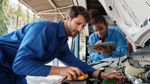 Mechaniker überprüfen ein Elektroauto in der Werkstatt.