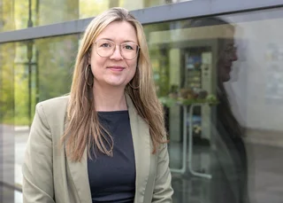 Frau mit Brille und langen blonden Haaren