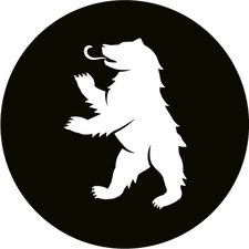 Ikonische Figur des Berliner Bären aus dem Stadtwappen, aufgerichtet mit erhobener Pfote und herausgestreckter Zunge auf schwarzem kreisförmigem Hintergrund.