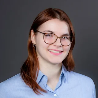 Frau mit Brille und langen braunen Haaren