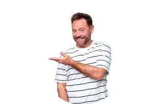 Älterer Mann im weißen Shirt mit schwarzen Streifen lächelt und zeigt mit der Hand nach links.