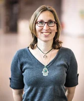 Frau mit Brille und kurzen dunkelblonden Haaren