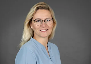 Frau mit Brille und langen blonden Haaren