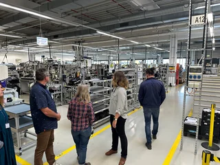 Beratende schauen sich in einer Fertigungshalle um